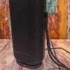 Front view of the Monster DNA Max portable Bluetooth speaker with wireless charging with included wrist strap attached. Front view of the Monster DNA Max portable Bluetooth speaker with wireless charging with included wrist strap attached