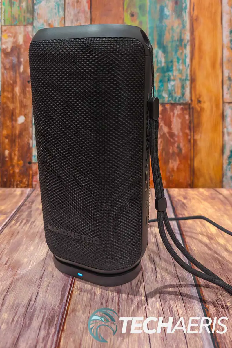 Front view of the Monster DNA Max portable Bluetooth speaker with wireless charging with included wrist strap attached